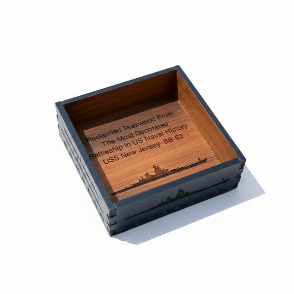 Wooden box with engraved text on a cardboard surface