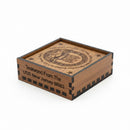 Wooden box with engraved text and design on a beige background