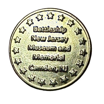 Bronze coin with text 'Battleship New Jersey Museum and Memorial Camden, NJ' on a wooden surface