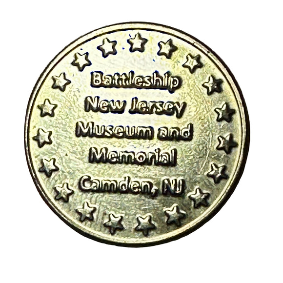 Bronze coin with text 'Battleship New Jersey Museum and Memorial Camden, NJ' on a wooden surface