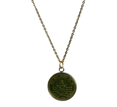 Gold necklace with a round pendant on a white background