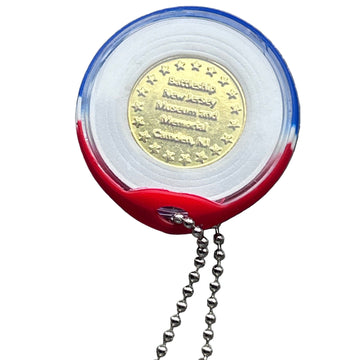 Gold coin in a red, white, and blue holder with a chain on a gray surface