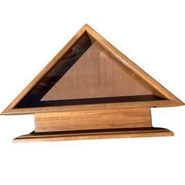 Wooden triangle-shaped object on a concrete surface