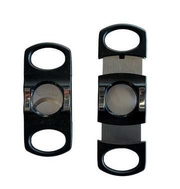 Two black battleship logo cigar cutters with stainless steel blades, one cutter showing the blade side by side with the closed cutter, placed on a white surface.