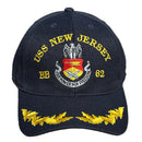 Navy blue cap with USS New Jersey and yellow text on a concrete surface