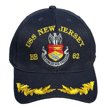 Navy blue cap with USS New Jersey and yellow text on a concrete surface