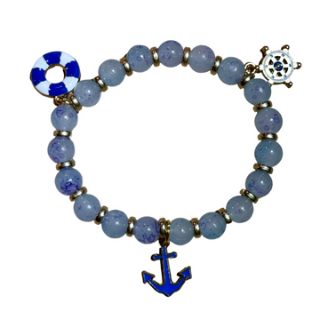 Bracelet with blue beads and anchor charm on a wooden surface