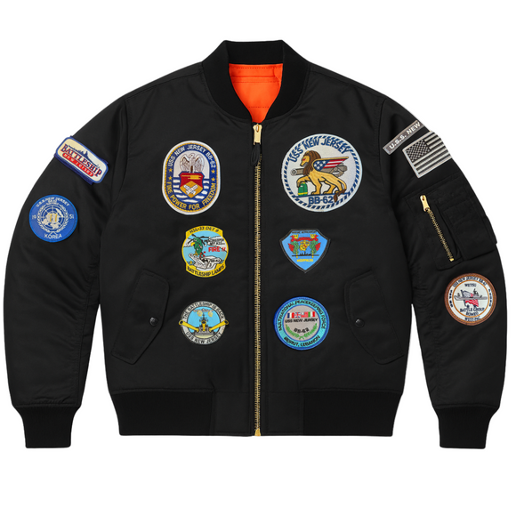 Black jacket with various patches on a white background