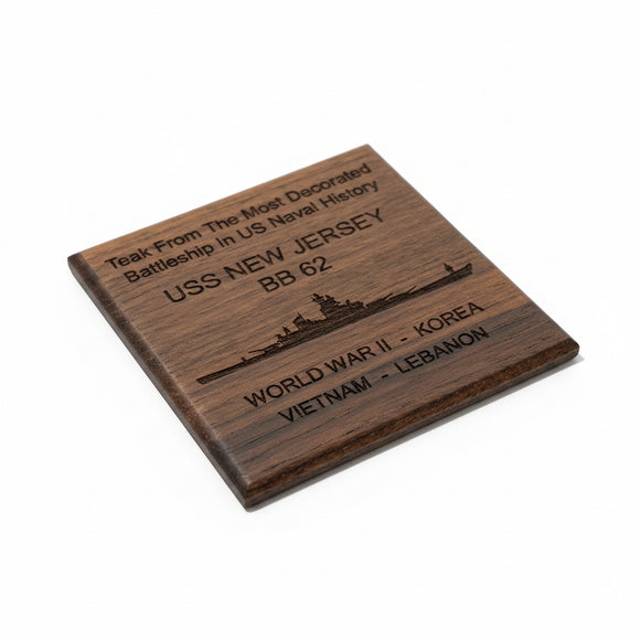 Wooden plaque with engraved text about USS New Jersey on a beige surface.