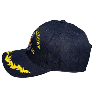 Blue cap with yellow text and emblem on a concrete surface