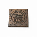 Wooden plaque with engraved text and star design on a textured surface