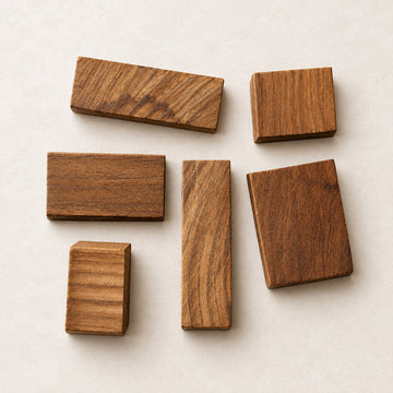 Six rectangular wood blocks of varying sizes and natural wood grain patterns arranged on a light-colored wooden surface.