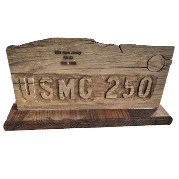 Wooden plaque with 'USMC 250' engraving on a concrete floor