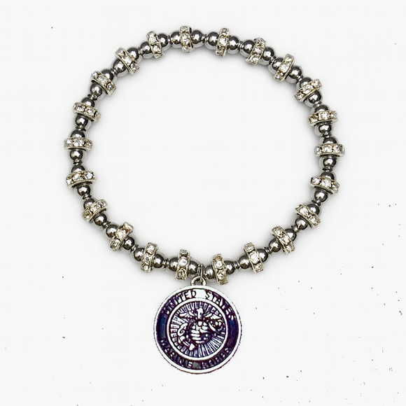 Silver beaded bracelet with a purple pendant on a white background