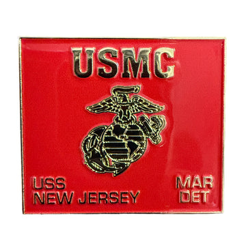 Red USMC badge with gold text and emblem on a wooden surface