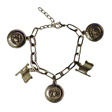 Silver charm bracelet on a black background with a ruler for scale.