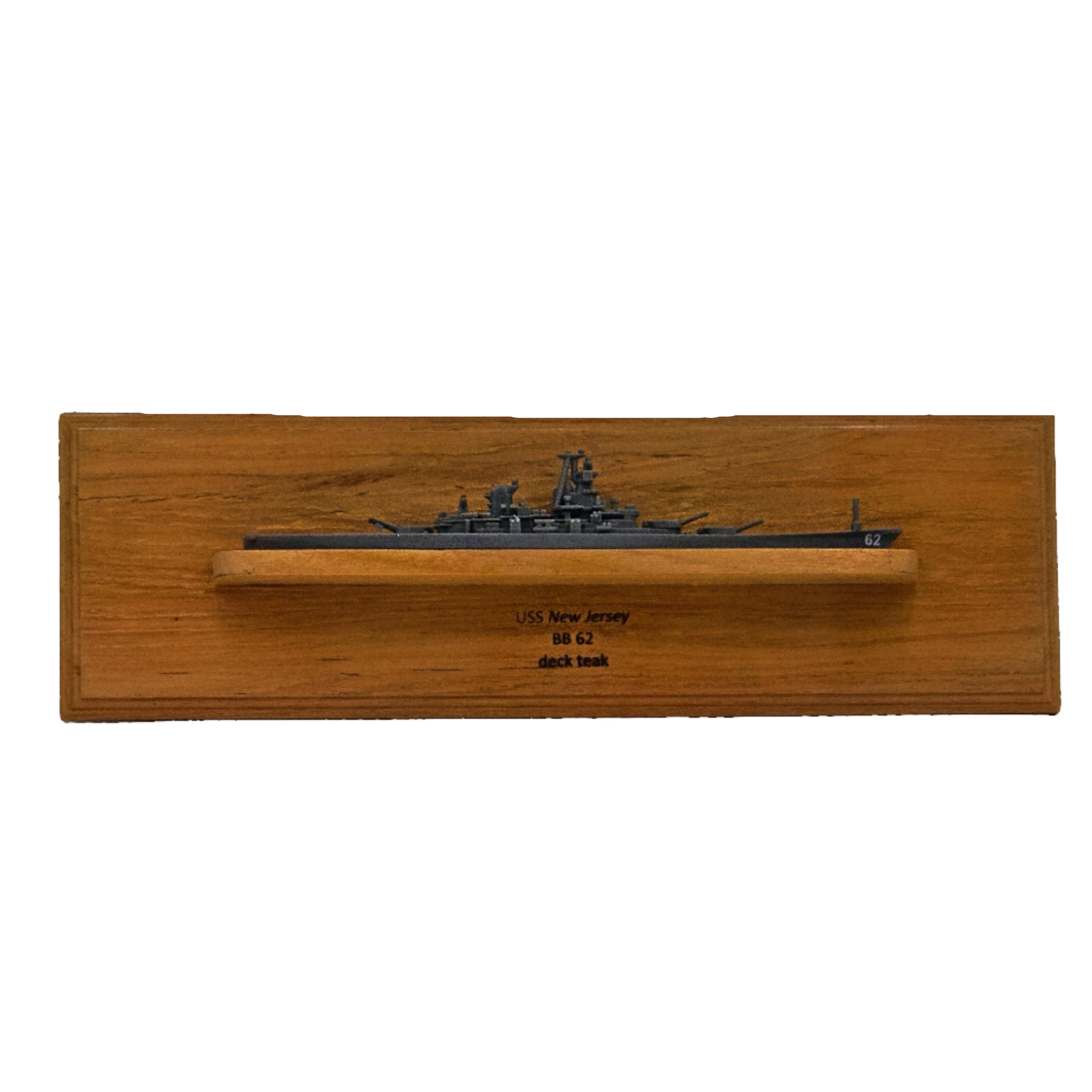 Wooden box with a ship model on top against a white wall